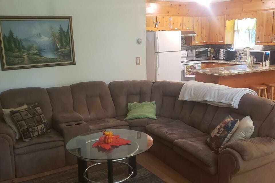 Long wrap around sofa adds a cozy feel while enjoying the fire with friends and family. Couch folds out to a sofa bed. Plenty of extra couch pillows and blankets for comfort.Breakfast bar has bar stools for extra seating in kitchen