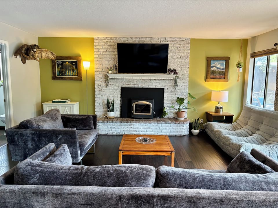 Main living room with tv and access to outdoor pergola and deck area.
