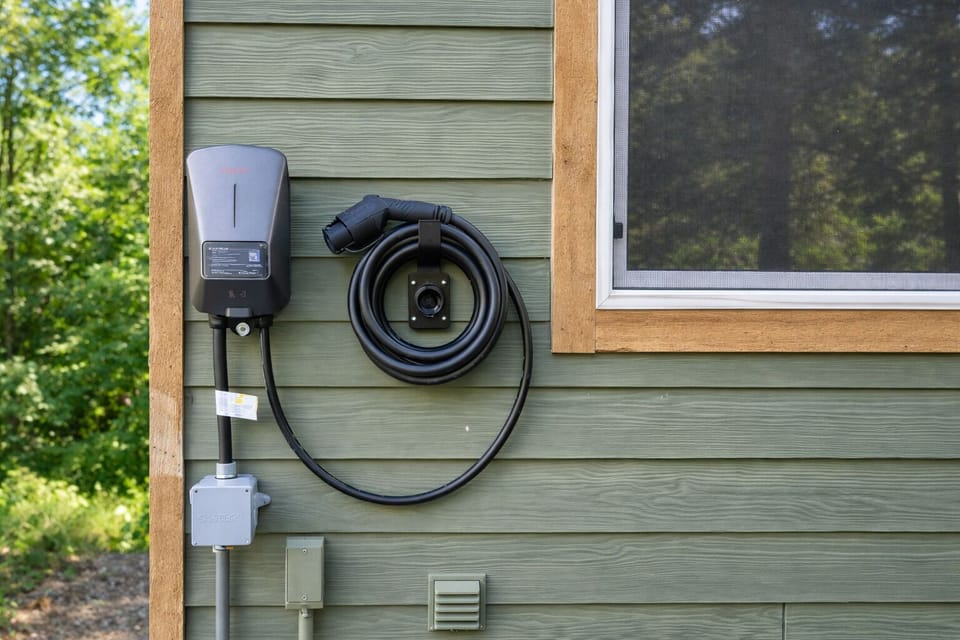 Electric vehicle charging station conveniently mounted on the property exterior for eco-conscious travelers.