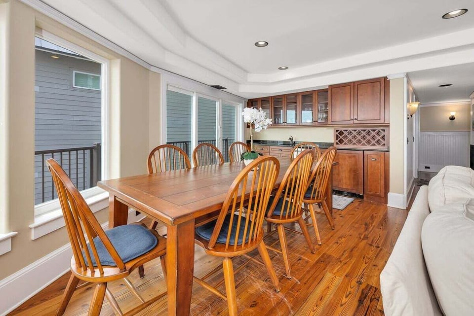 Dining room with wood table, eight chairs, and large windows