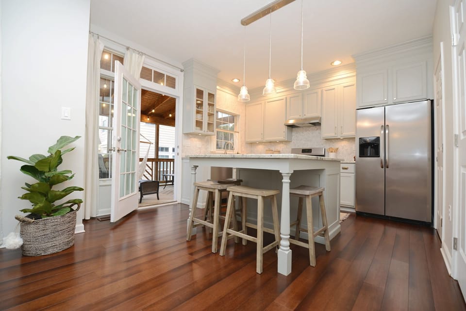 Fully-stocked kitchen has room for 10 at a granite island and a table nearby.