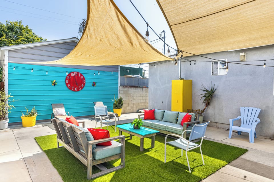 Super fun and vibrant outdoor space to hangout and enjoy the weather! Large dining table, cornhole, sofa seating, BBQ, sun loungers, etc