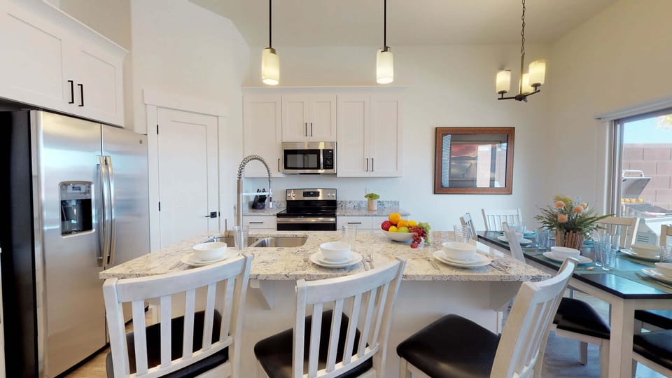 Beautiful modern all white kitchen with bar seating and dining