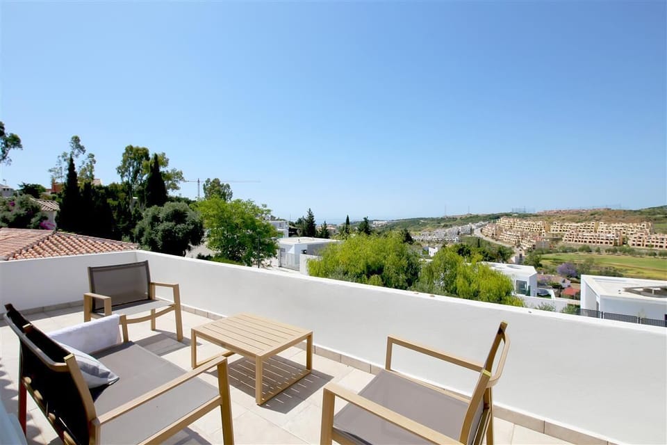 Upper terrace with outdoor seating for four guests and distant sea views