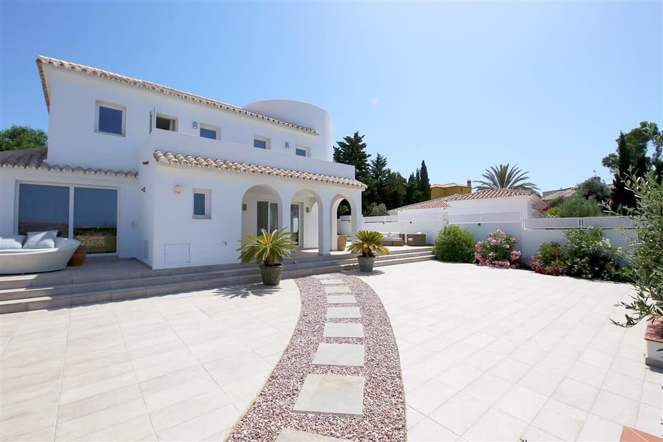 View of the house from the entrance with gardens and outdoor seating