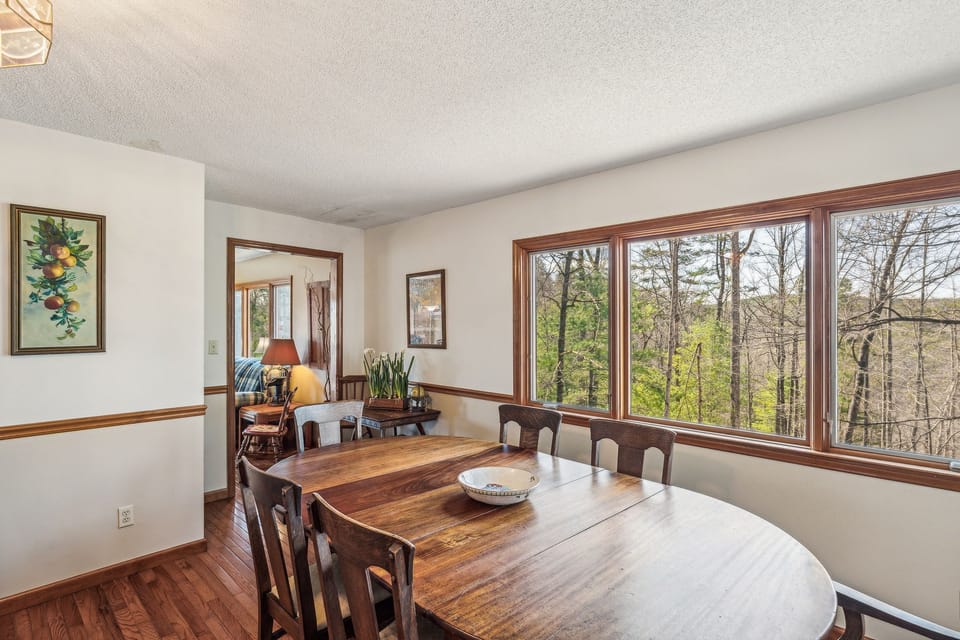 Main level family room with a wood burning fireplace and additional dining space
