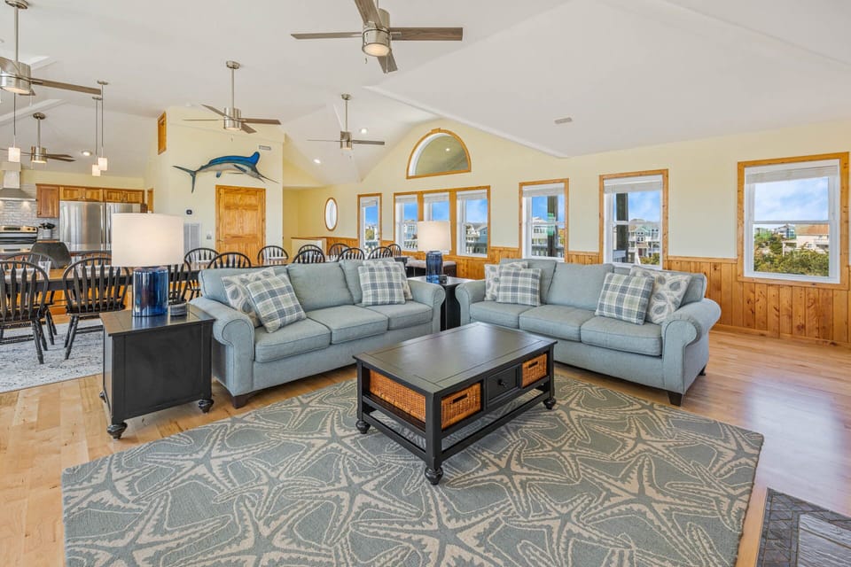 The great room offers several plush couches, conveniently alongside the large dining area.
