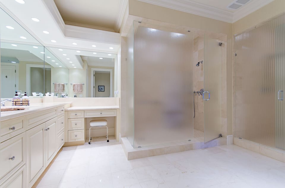 Master Bathroom is split into his and hers with two showers, vanities, toliets.