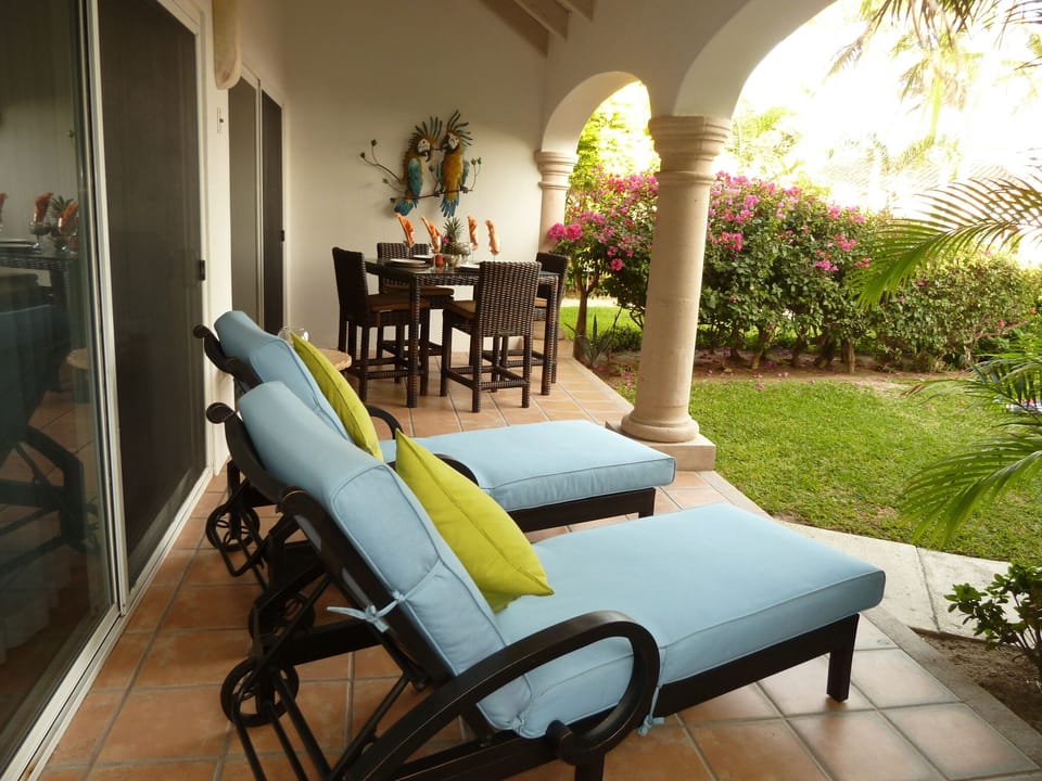 Sunny patio with beautiful views of the manicured garden, swimming pool & ocean