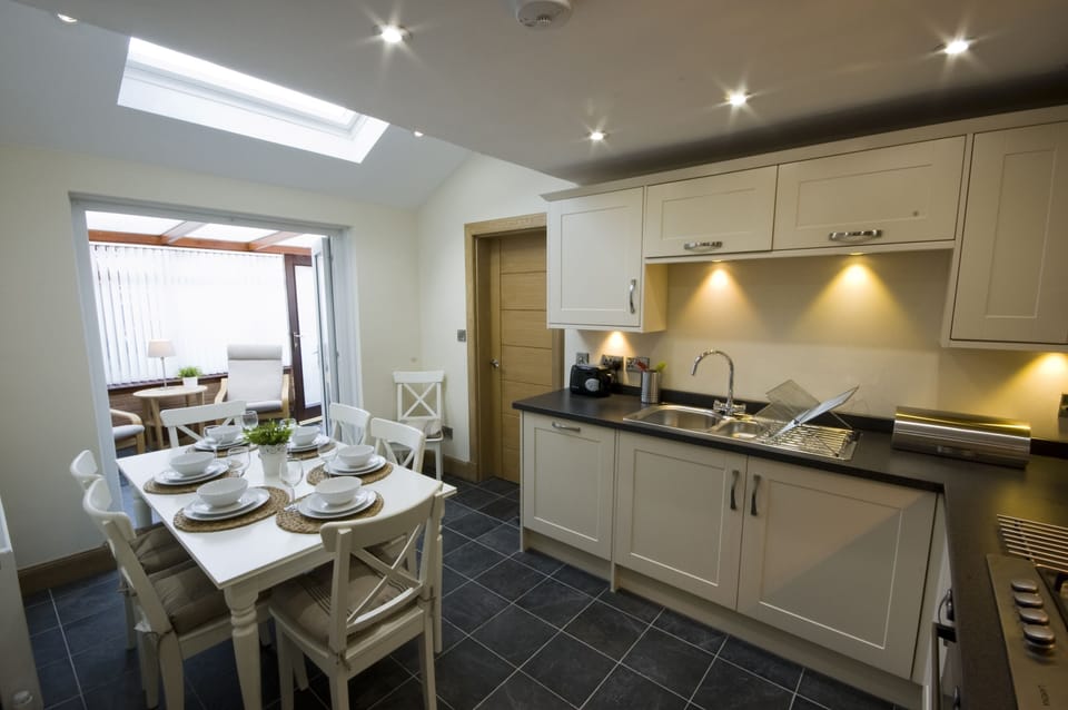 Fully fitted kitchen  with dining table leading off to sun-room