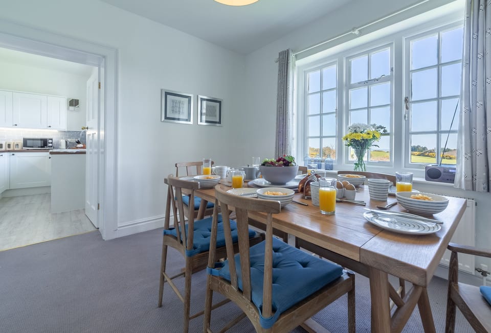 Ground floor: Dining room leading to kitchen with views across the golf course