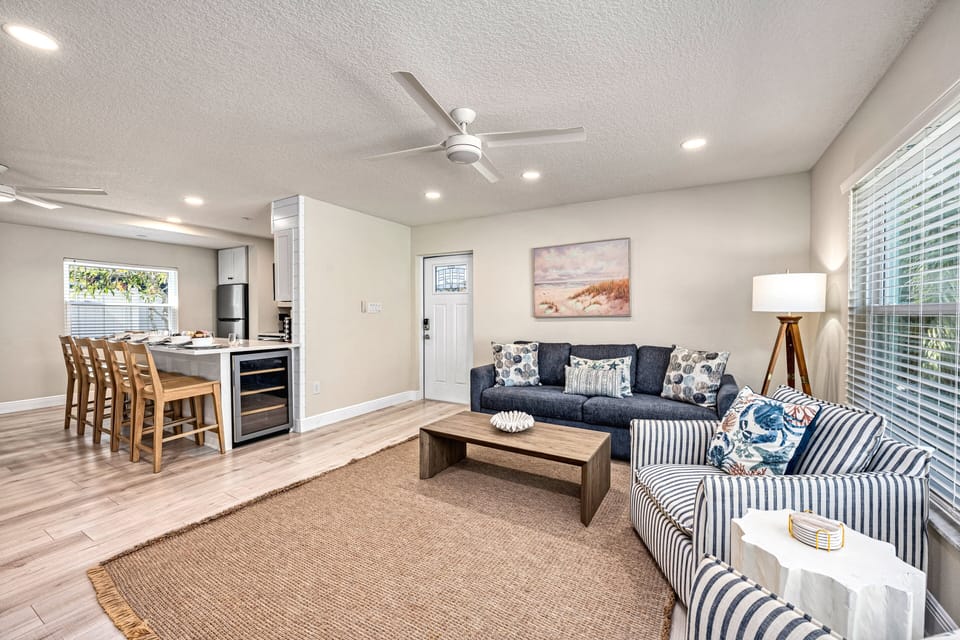 The heart of the home blends open living and dining beautifully—kitchen bar stools, plush seating, and a sun-filled layout make gathering easy and natural.