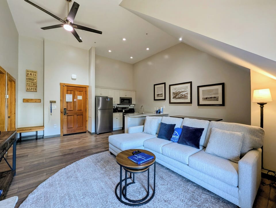 Your open-concept living space features vaulted ceilings, modern furnishings, and a fully equipped kitchenette—perfect for unwinding after your mountain adventures.
