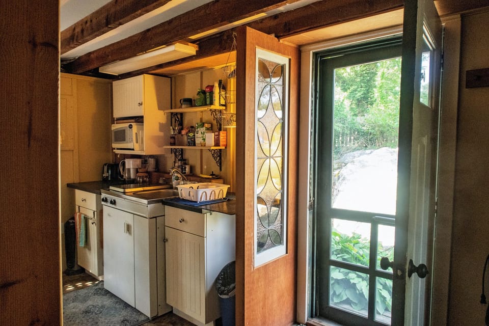 The front door with screen door and the kitchenette.