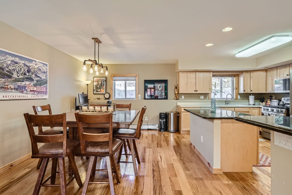 dining table with computer desk in corner next to gourmet kitchen.