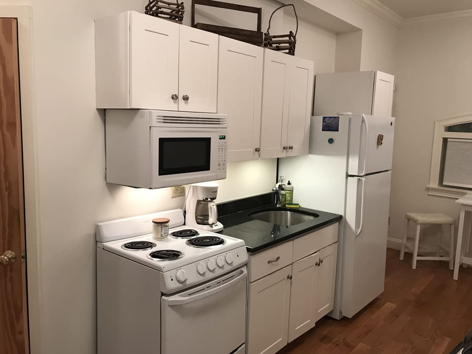 Cozy efficiency kitchen. Full size appliances: microwave, stove/oven, fridge.