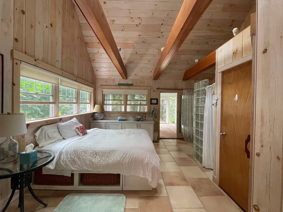 Spa room with queen bed, cathedral ceiling, and screened porch