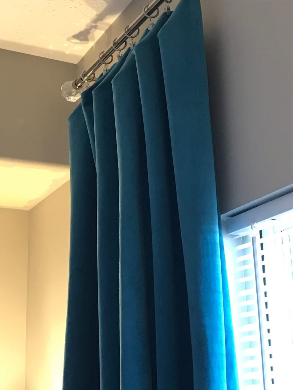 Custom teal velvet drapes easily slide with rings and rod.