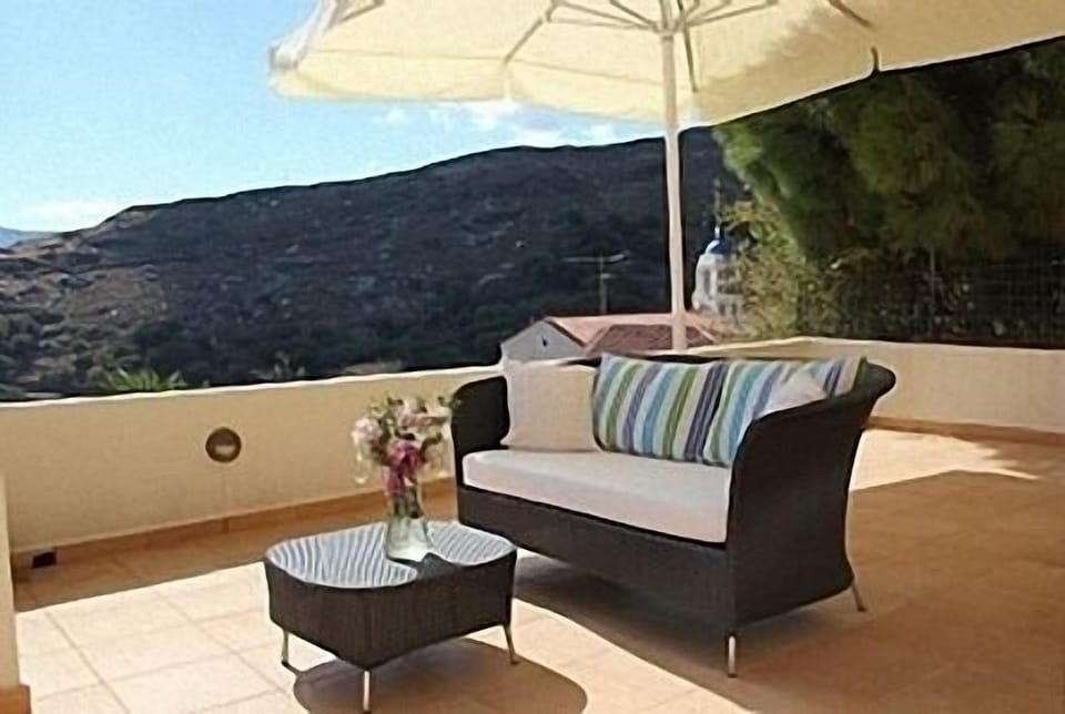 veranda, furniture, large umbrella, near-by church 