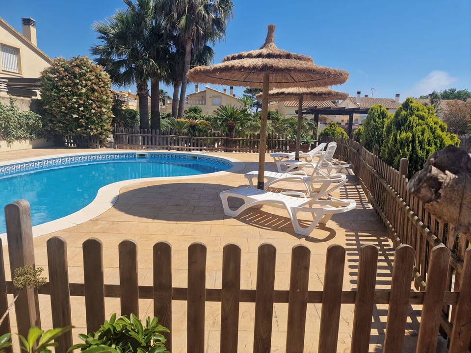 Enjoy the stunning view from the terrace directly onto the large pool and well-maintained garden at holiday home Eva. Check availability now!