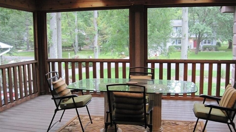Screened in porch with cushioned seating and hammock (not in photo)