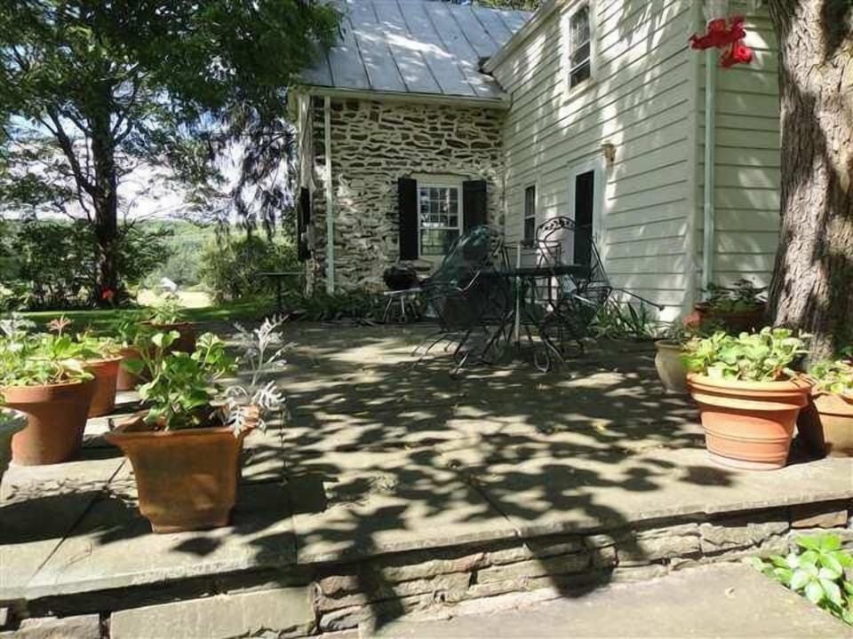Blue stone patio with wrought iron table and chairs and Weber Grill.