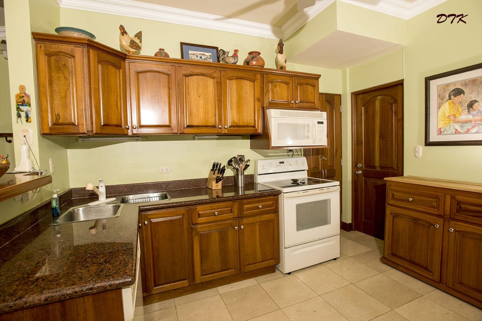 Kitchen with door to utility room and movable kitchen island/cupboards.