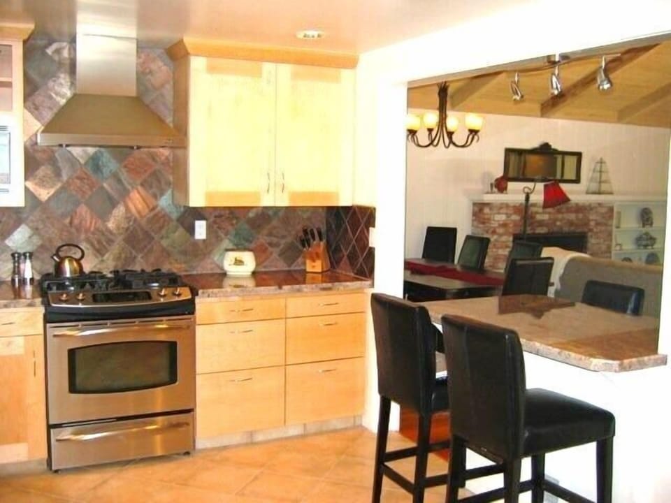 Copper slate backsplash, Stainless steel appliances and tiled flooring.