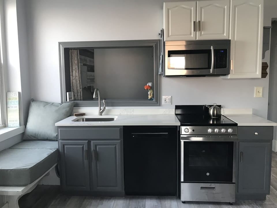 Glass top stove/oven with 4 burners, microwave and full-sized Bosch dishwasher.
