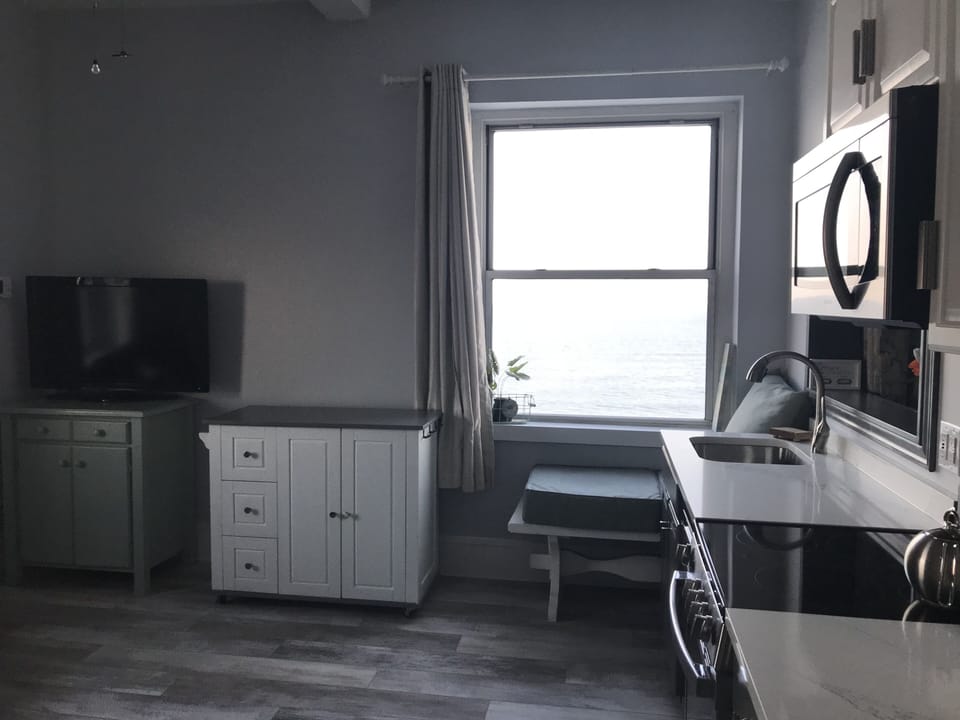 Kitchen island has a drop leaf in the back & there are 2 saddle style stools.