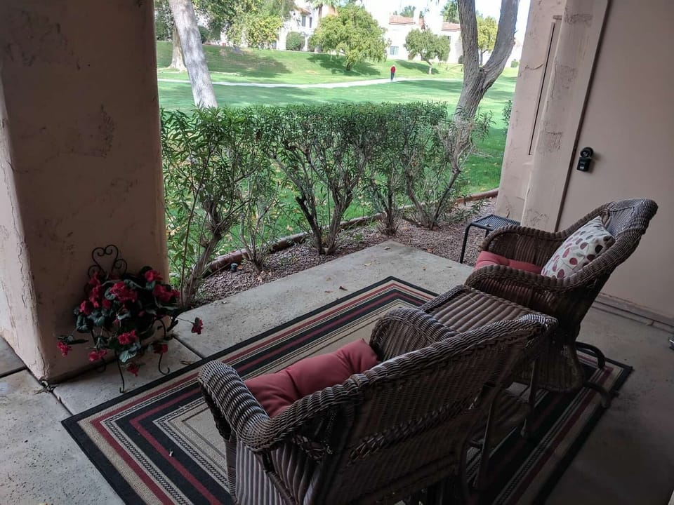 Patio with seating overlooking green space.