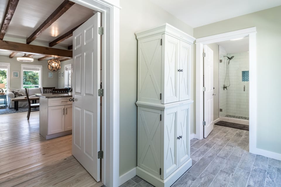 Upper cabinet holds pool towels and lower cabinet holds small kitchen appliances