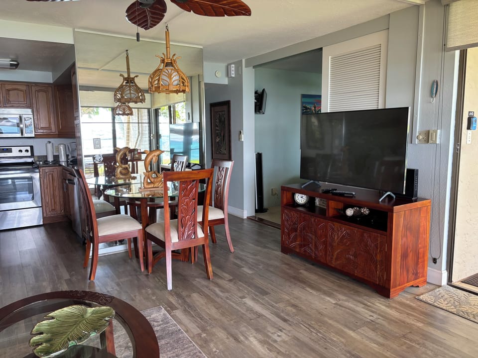 A view of the living room with a 55 inch TV and the bedroom doorway