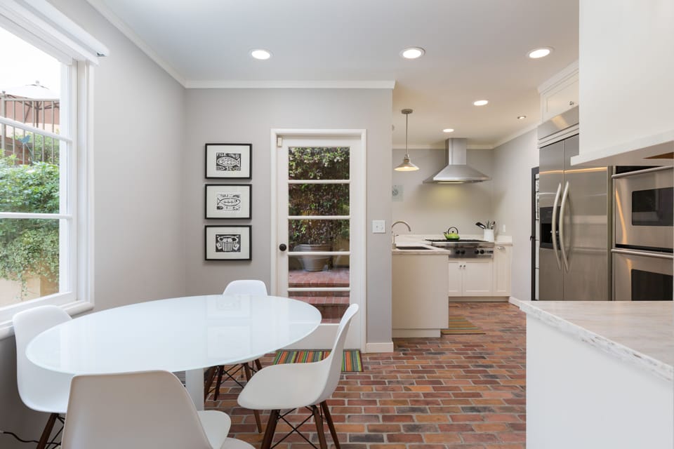 Gourmet kitchen with split brick flooring and dining area