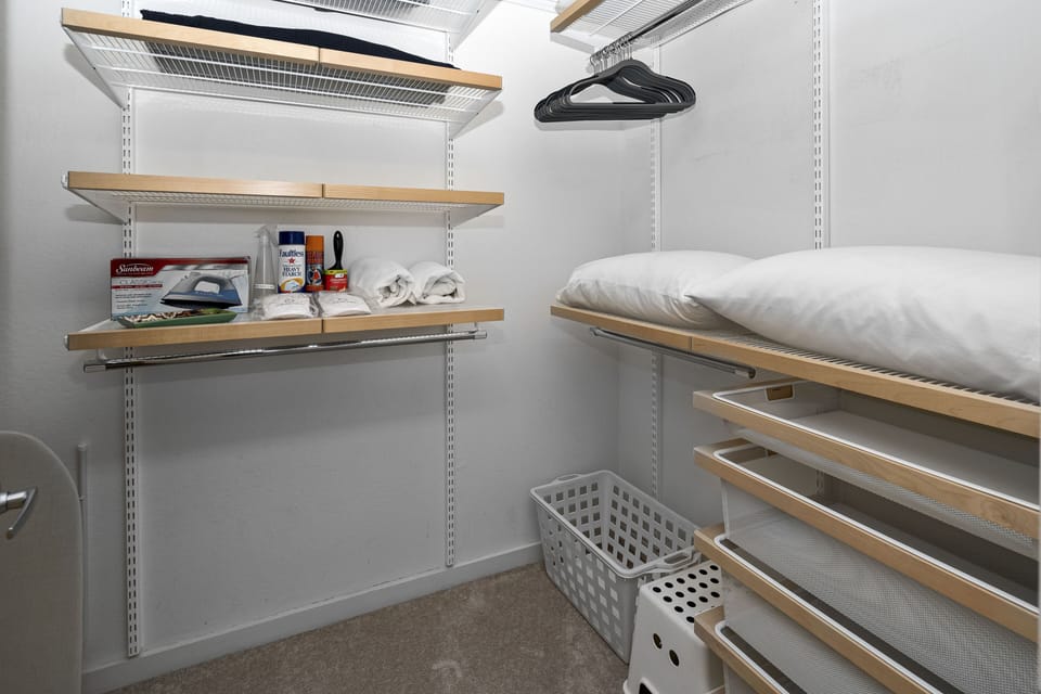 Built-in dresser in closet with lots of hangers and shelf space.