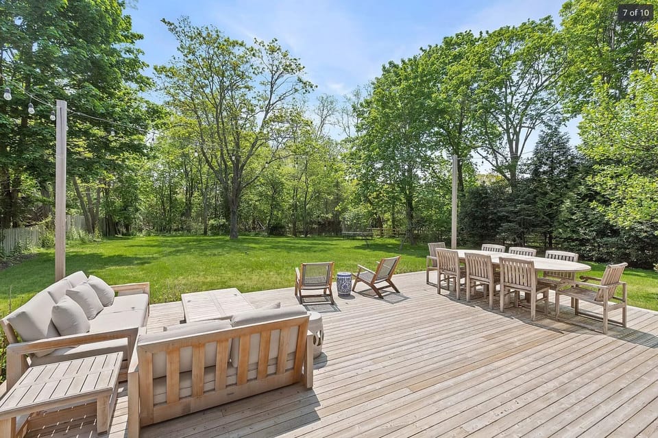 Large dining deck with new teak furniture, lounge chairs, and hidden Weber grill