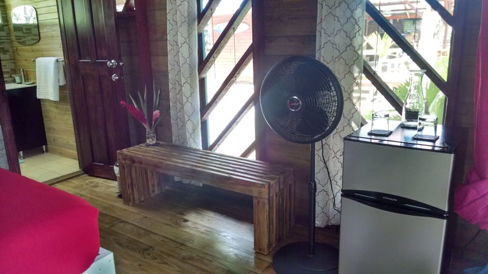 Handmade bench, tropical flowers, floor fan, mini-refrigerator & water carafe 