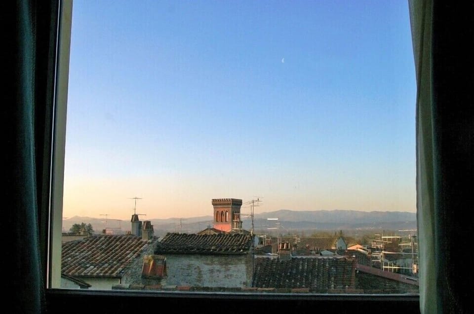 A romantic sunset and moon above Sansepolcro's rooftops from the bedroom window
