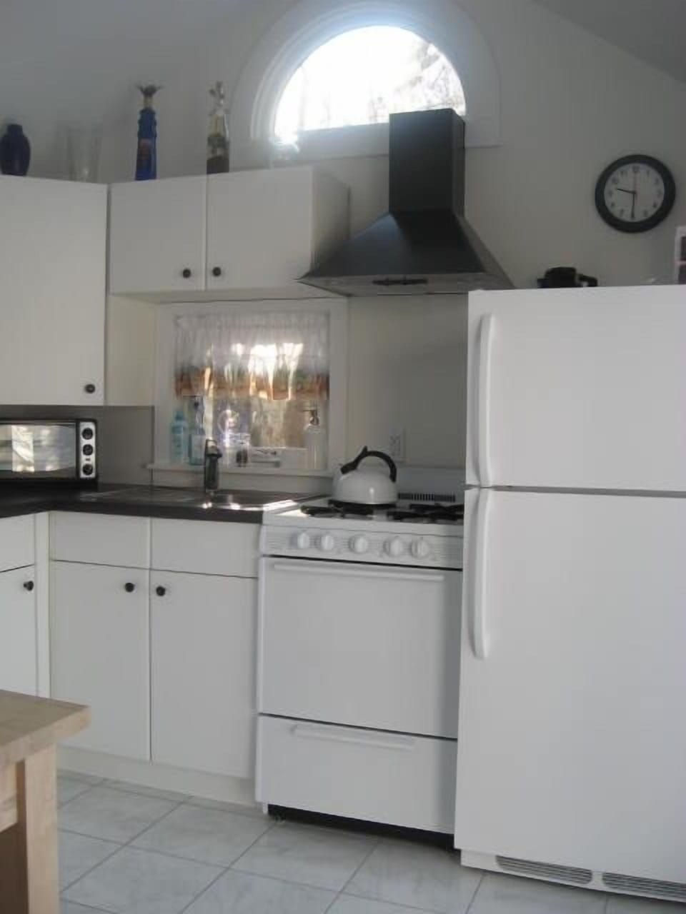 Galley kitchen with Eyelid window, skylights,  & sliding door to the sunny deck.