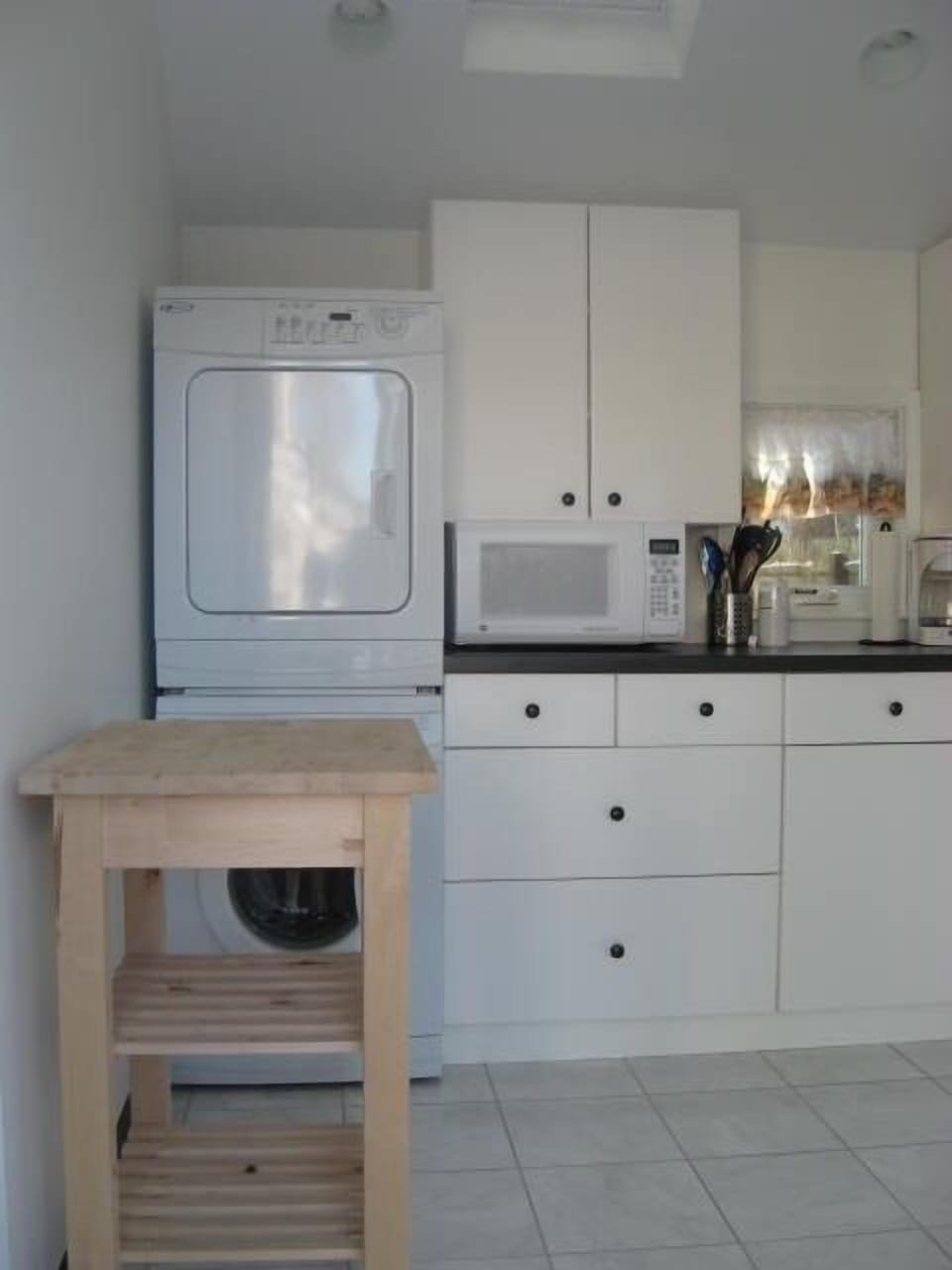 Kitchen with European stack washer & dryer, microwave,  cabinets & Lazy Susan.