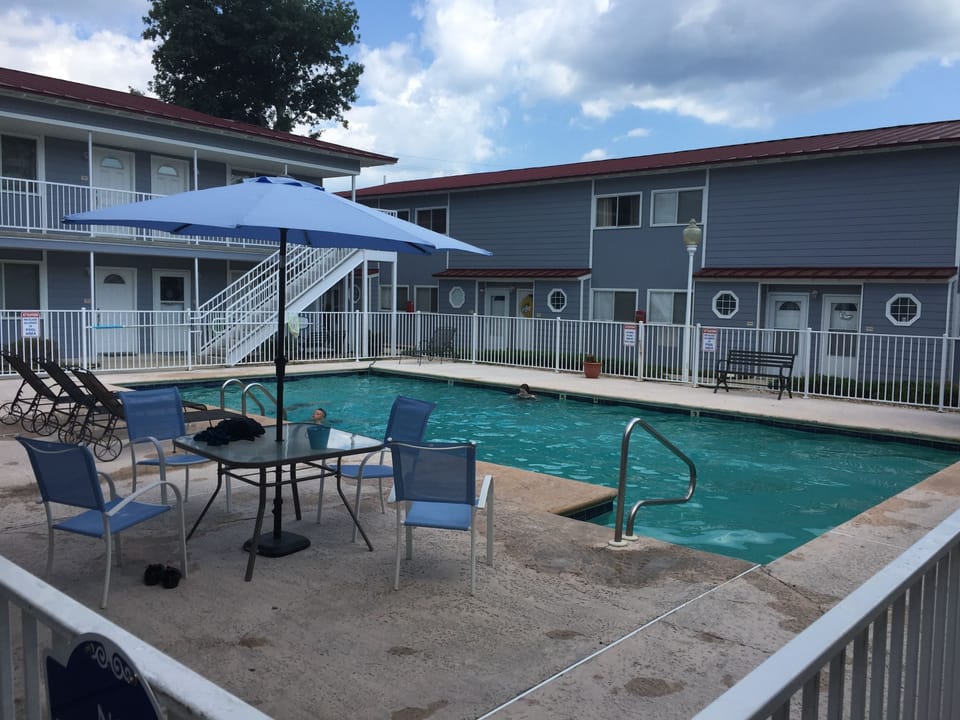 Large swimming pool area with furniture and clubhouse.