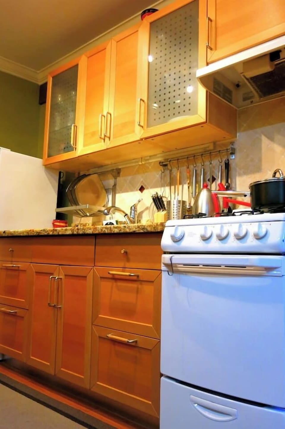 Kitchen cooking area w/ stove, hanging utensils & easy access to pots & pans