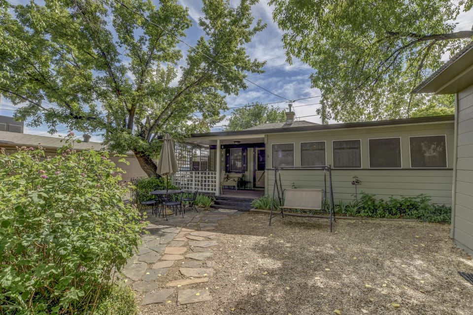 The front yard is shaded with elm trees and fenced
