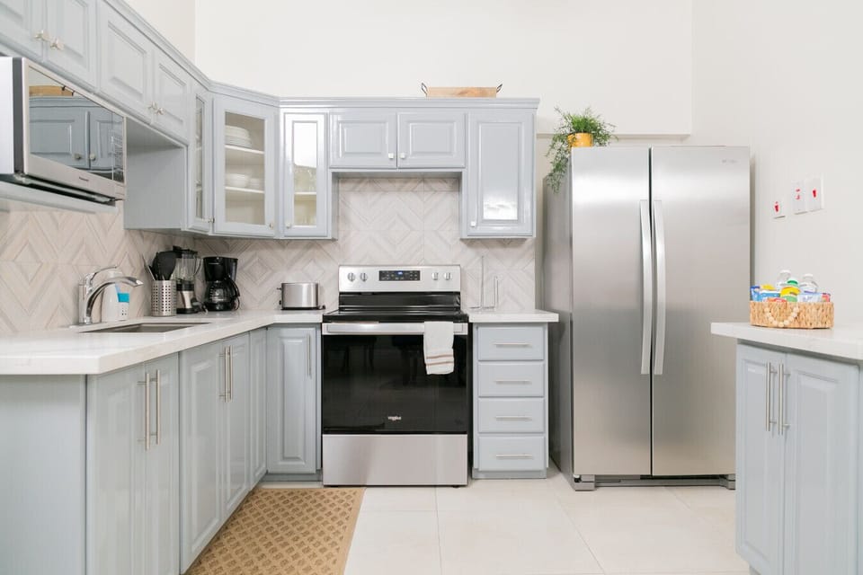 Fully equipped kitchen w/ stainless appliances, gray cabinetry & ample counter space.