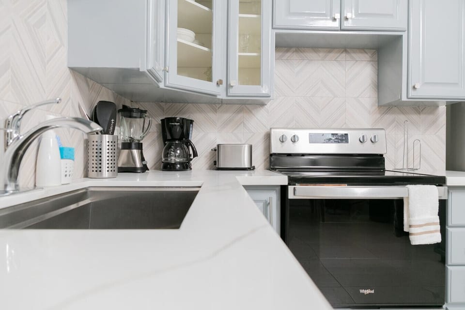 Sleek kitchen counter w/ sink, coffee maker & modern appliances for easy mornings.