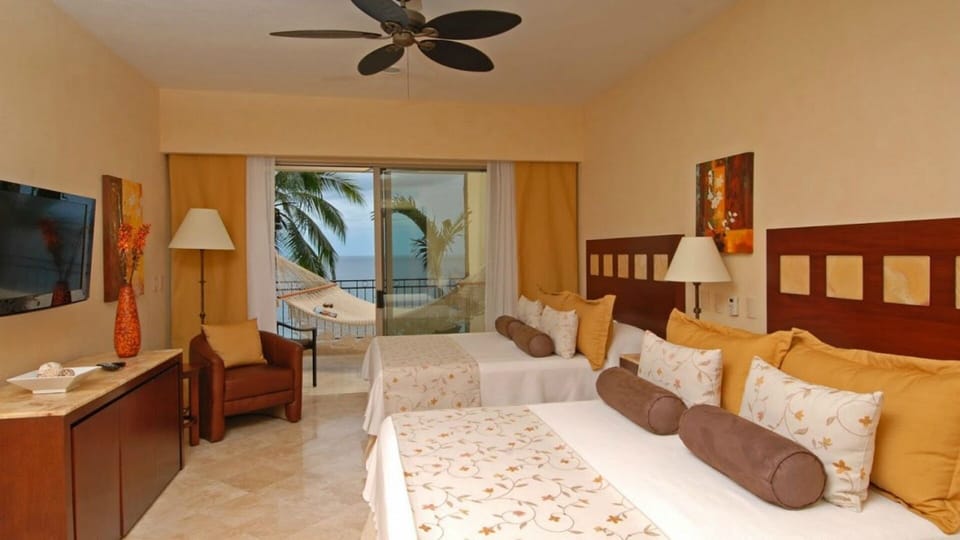 Bedroom 2 has two queen sized beds and walks out to the balcony.
