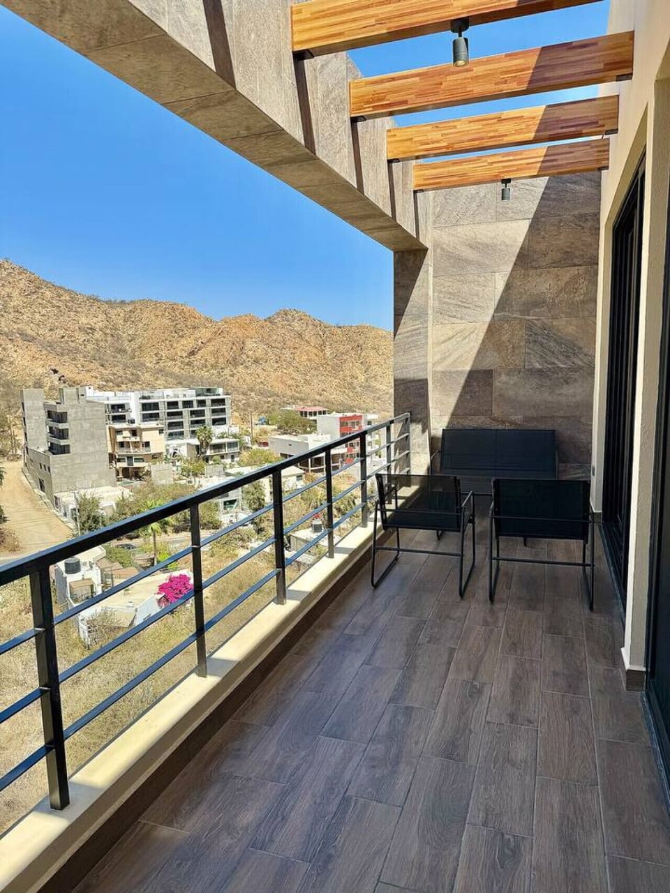 Private balcony with panoramic mountain and city views, perfect for morning coffee.