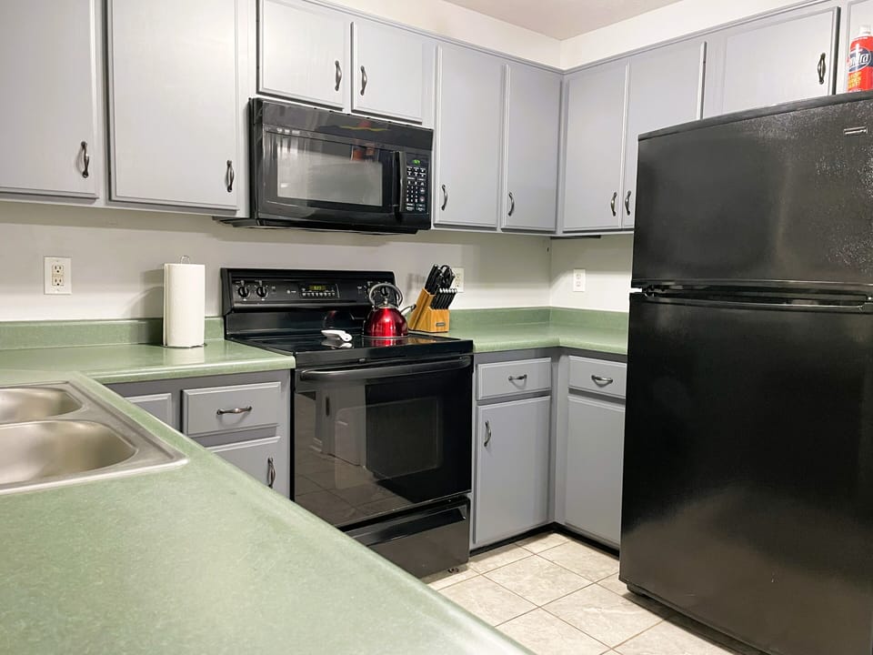 Full-sized refrigerator, microwave, oven, and glass cooktop.

