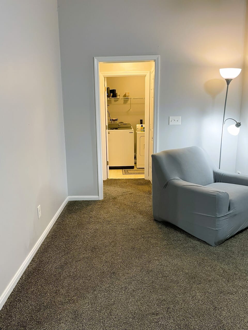 Hallway from family room to laundry room. Garage door on R. Master bed on L.