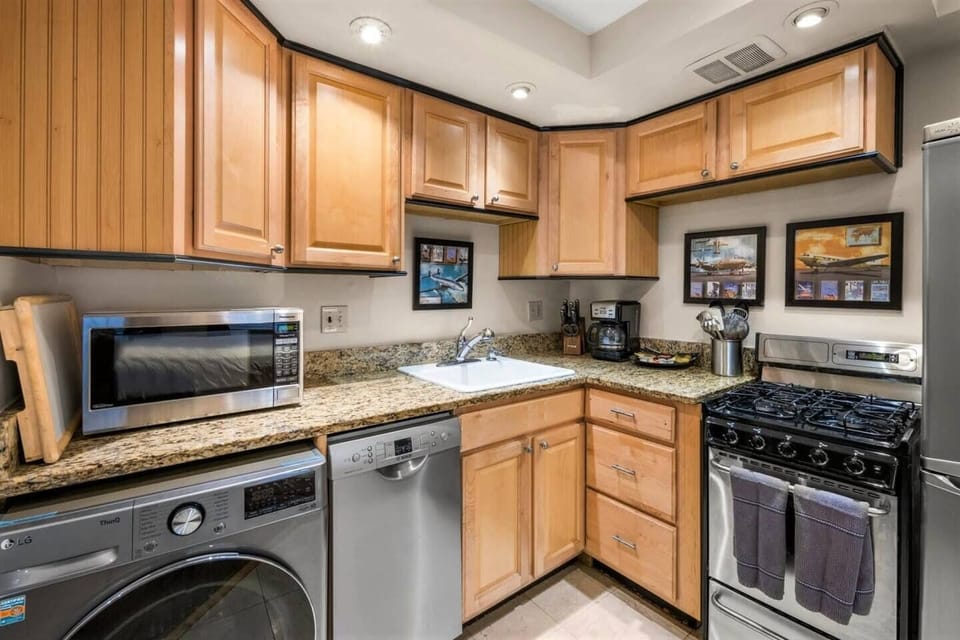 Kitchen with granite counters and combo washer/dryer and Bosch dishwasher